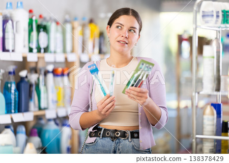 Portrait young woman choosing best toothbrush in supermarket 138378429