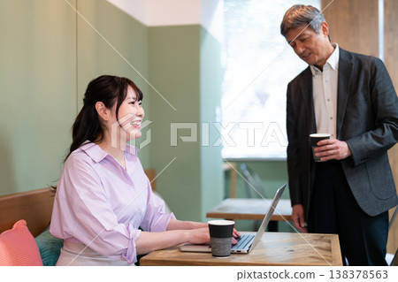 Male and female office workers discussing work-related matters at a coworking space. Male and female office workers discussing work-related matters at a coworking space. 138378563
