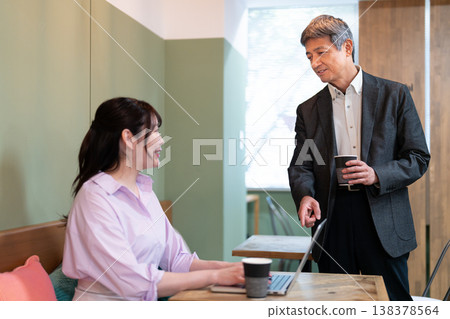 Male and female office workers discussing work-related matters at a coworking space. 138378564