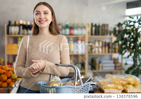Visiting store, girl is looking at something on shelf of showcase. Visiting store, girl is looking at something on shelf of showcase. 138378596