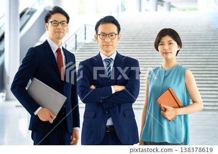 日本商務團隊自豪地站在辦公大樓大廳。 日本商務團隊自豪地站在辦公大樓大廳。 138378619