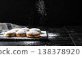 黑色背景上的甜甜圈，撒滿了糖粉。 138378920