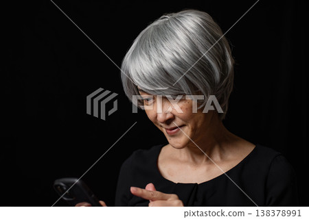 一位老年婦女正在使用智慧型手機的圖片 138378991