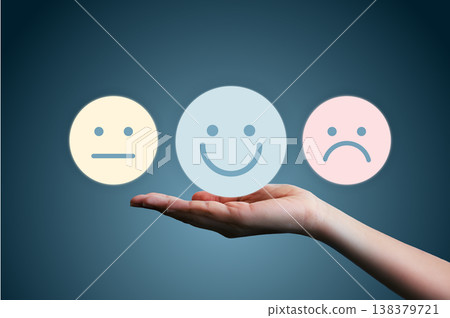 Hand holding happy smile, neutral, and sad face icons on blue background. Concept of customer satisfaction survey, excellent service rating, feedback, client experience, and emotion evaluation. Hand holding happy smile, neutral, and sad face icons on blue background. Concept of customer satisfaction survey, excellent service rating, feedback, client experience, and emotion evaluation. 138379721