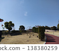 A park on a sunny day and a Ferris wheel in the distance. 138380259