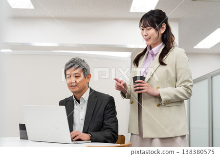 A female employee explaining something to a man in the office. A female employee explaining something to a man in the office. 138380575