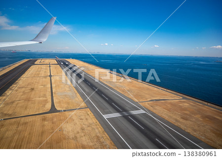 The runway as seen from the window of a plane after takeoff. 138380961