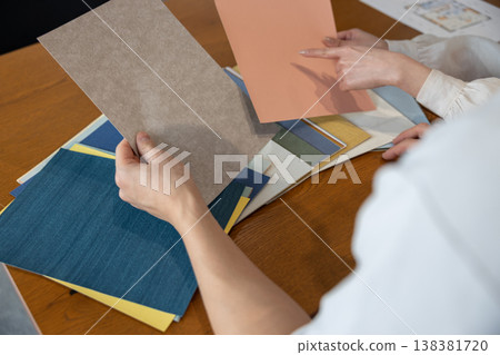 一對年輕夫婦手裡拿著壁紙樣品，正在討論這個問題。 138381720