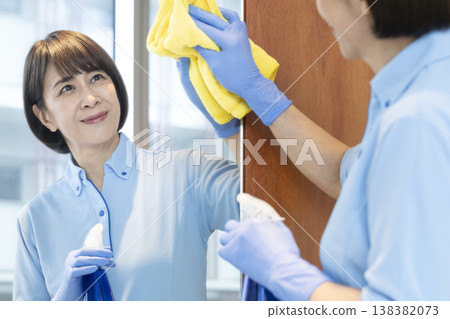 Senior female cleaning staff wiping surfaces Senior female cleaning staff wiping surfaces 138382073