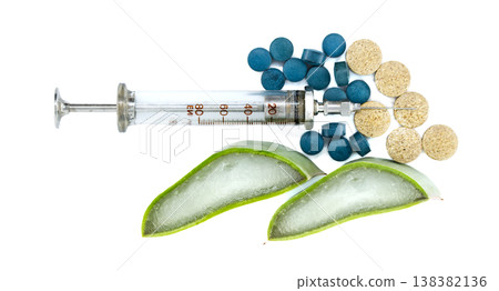 Vintage syringe with aloe vera slices and assorted pills on white background Vintage syringe with aloe vera slices and assorted pills on white background 138382136