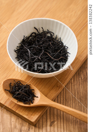 Dried hijiki seaweed, a Japanese food ingredient served in a small white bowl. 138382242