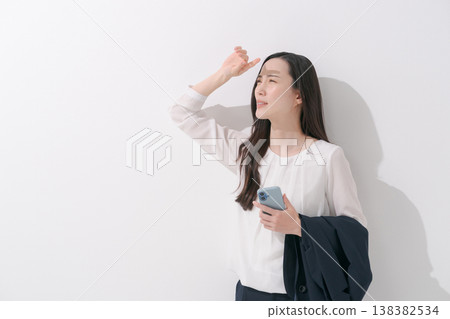 一張女性在炎熱夏季身穿職業套裝工作的照片。 138382534