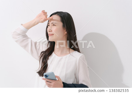 一張女性在炎熱夏季身穿職業套裝工作的照片。 138382535
