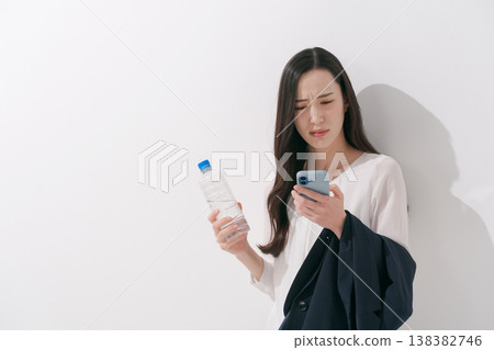 一張女性在炎熱夏季身穿職業套裝工作的照片。 138382746
