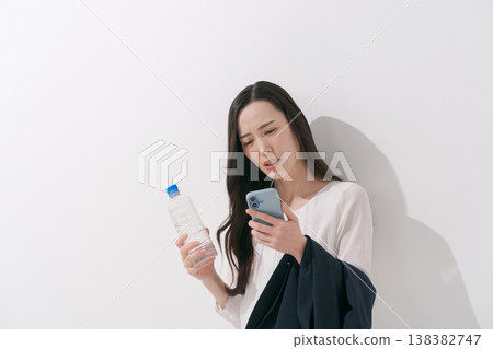 一張女性在炎熱夏季身穿職業套裝工作的照片。 138382747