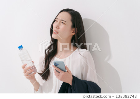 一張女性在炎熱夏季身穿職業套裝工作的照片。 138382748