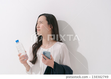 一張女性在炎熱夏季身穿職業套裝工作的照片。 138382749