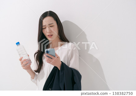 一張女性在炎熱夏季身穿職業套裝工作的照片。 138382750
