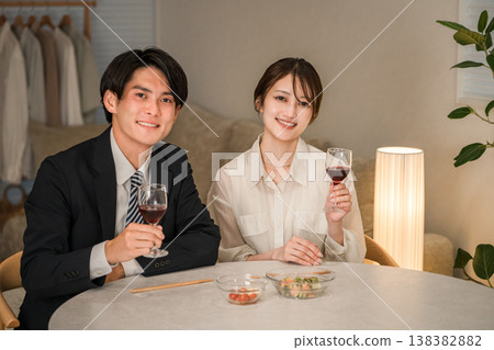 一對夫婦在傍晚的餐桌旁享用葡萄酒。 一對夫婦在傍晚的餐桌旁享用葡萄酒。 138382882