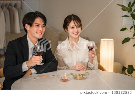 一對夫婦在傍晚的餐桌旁享用葡萄酒。 一對夫婦在傍晚的餐桌旁享用葡萄酒。 138382883