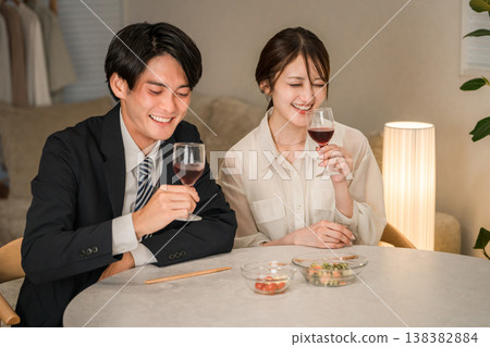 一對夫婦在傍晚的餐桌旁享用葡萄酒。 一對夫婦在傍晚的餐桌旁享用葡萄酒。 138382884