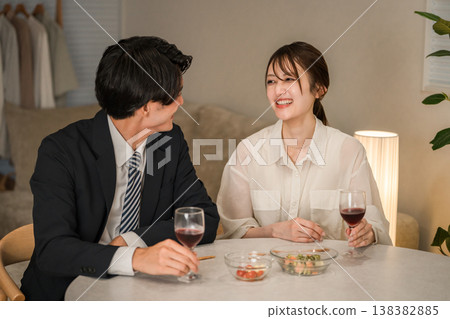 A couple enjoying wine at the dining table in the evening. A couple enjoying wine at the dining table in the evening. 138382885