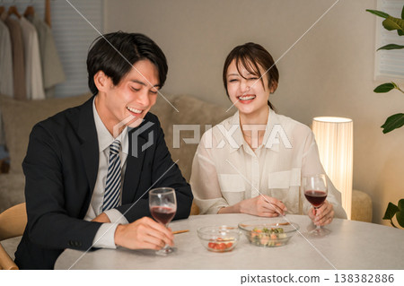 一對夫婦在傍晚的餐桌旁享用葡萄酒。 一對夫婦在傍晚的餐桌旁享用葡萄酒。 138382886