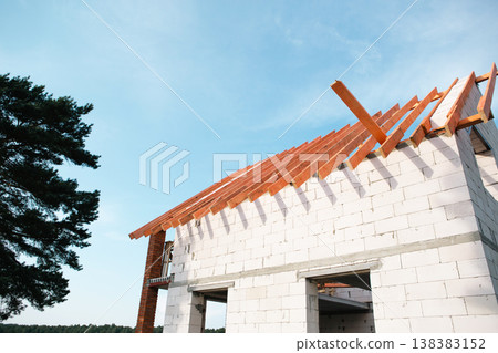 Contemporary house with wooden roof lags installed, brick and block walls, stropil system evolve, building covered by home insurance and construction loan. 138383152