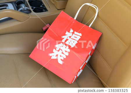 A lucky bag placed on the seat of a luxury car 138383325