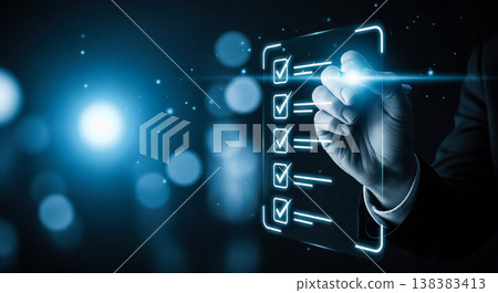 Businessman hand writing on glowing digital checklist screen representing corporate task management successful business planning modern technology strategy goals achievement future progress 138383413