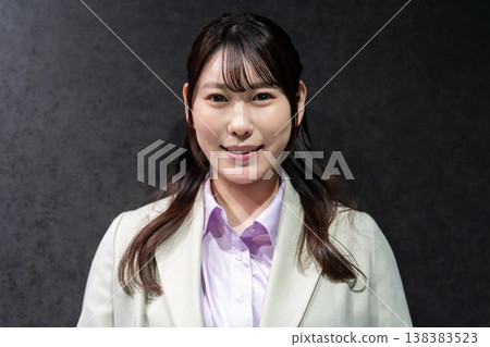 A businesswoman in a suit smiles and looks straight ahead. A businesswoman in a suit smiles and looks straight ahead. 138383523