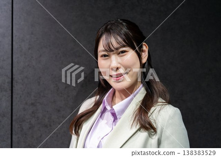 一位身著職業套裝的女商人面帶微笑,目視前方。 一位身著職業套裝的女商人面帶微笑,目視前方。 138383529