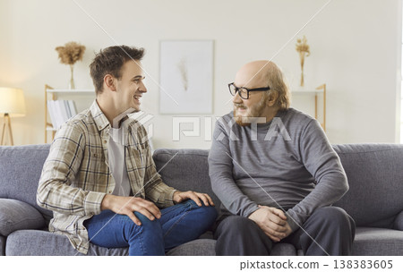 Senior father and adult son at home together, two generations male family enjoying talking, chatting Senior father and adult son at home together, two generations male family enjoying talking, chatting 138383605