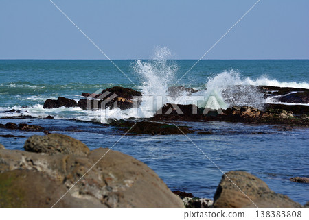 白色的海浪猛烈地拍打著岩石海岸,激起的白色浪花高高飛起;這是福島縣磐城市波立海岸的礁石和浪花。 白色的海浪猛烈地拍打著岩石海岸,激起的白色浪花高高飛起;這是福島縣磐城市波立海岸的礁石和浪花。 138383808