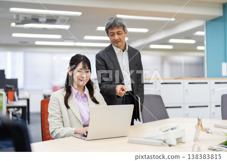 辦公室裡的商務人士互相討論和建議工作相關事宜。 138383815