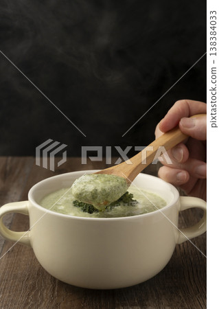 Lift the steaming broccoli potage with a spoon. Lift the steaming broccoli potage with a spoon. 138384033