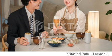 A young Asian couple (beer, canned beer) eating and drinking at their dining table in their home. A young Asian couple (beer, canned beer) eating and drinking at their dining table in their home. 138384420