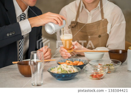 A young Asian couple (beer, canned beer) eating and drinking at their dining table in their home. A young Asian couple (beer, canned beer) eating and drinking at their dining table in their home. 138384421
