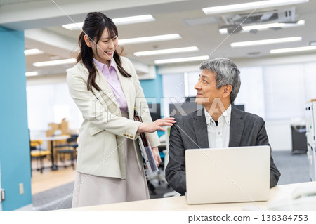 辦公室裡,商務人士面帶微笑,談笑風生。 辦公室裡,商務人士面帶微笑,談笑風生。 138384753