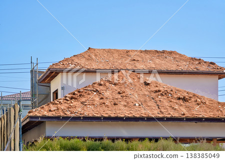 Demolition site of an old wooden house; roof covered with earth. 138385049