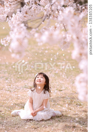 Children playing happily in a spring park amidst cherry blossoms in full bloom. Children playing happily in a spring park amidst cherry blossoms in full bloom. 138385105