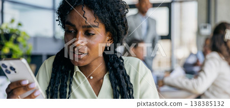 Female professional examines timesensitive message on mobile device Female professional examines timesensitive message on mobile device 138385132