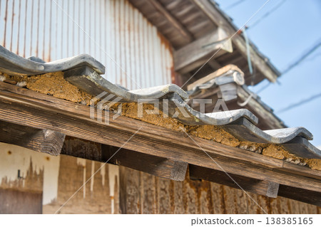 The eaves of an old wooden house with a tiled roof 138385165