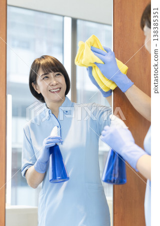 Senior female cleaning staff wiping surfaces Senior female cleaning staff wiping surfaces 138385351