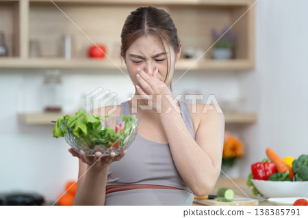 Woman reacting to unpleasant smell from a salad Woman reacting to unpleasant smell from a salad 138385791