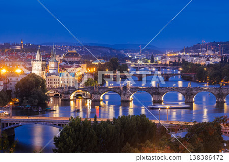 Night view of Prague with illuminated Charles Bridge over Vltava River, historic architecture and glowing city lights in famous European destination Night view of Prague with illuminated Charles Bridge over Vltava River, historic architecture and glowing city lights in famous European destination 138386472