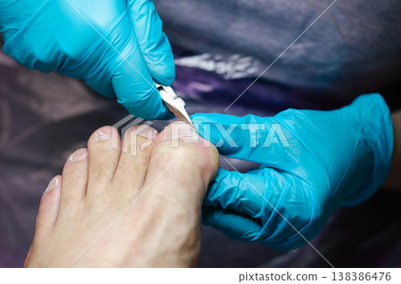 Professional Pedicure Procedure. Nail Technician Using Nail Clippers. Professional nail care service showing precise toenail cutting technique. Nail clippers. Professional Pedicure Procedure. Nail Technician Using Nail Clippers. Professional nail care service showing precise toenail cutting technique. Nail clippers. 138386476