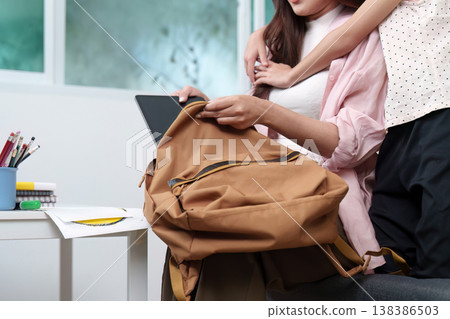 Parent organizing school supplies for child Parent organizing school supplies for child 138386503