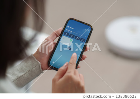 Smartphone controlling air purifier remotely Smartphone controlling air purifier remotely 138386522