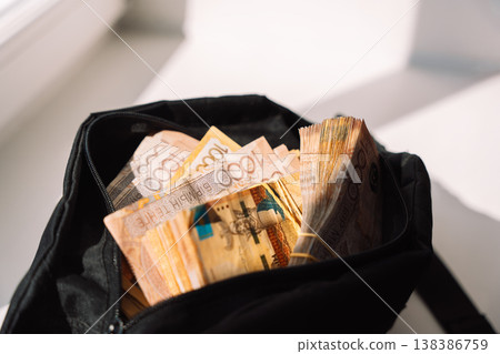Kazakhstani tenge banknotes packed in a black bag on windowsill, cash savings concept Kazakhstani tenge banknotes packed in a black bag on windowsill, cash savings concept 138386759